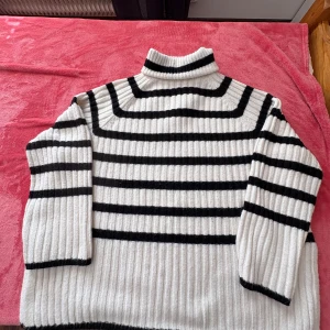 Randig polotröja från H&M - Säljer en snygg randig polotröja från H&M i svart och vitt. Tröjan är ribbad och har långa ärmar, perfekt för kyligare dagar. Den har en klassisk polokrage som ger extra värme och stil. Passar bra till både jeans och kjol! Stl är M passar då som oversize eller kan användas för den som har stl XL