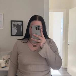 Beige ribbad tröja från Lager157 - Säljer en stilren beige ribbad tröja från Lager157. Tröjan har en v-ringad hals och långa ärmar, perfekt för en avslappnad look. Passar bra till både jeans och kjol. Hör av dig vid intresse!