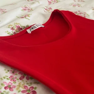 Röd klänning från Zara - Röd ärmlös klänning från Zara. Klänningen har en enkel och stilren design.