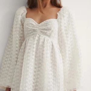 Vit spetsklänning från NA-KD - Säljer en romantisk vit spetsklänning från NA-KD med långärmad design och v-ringad detalj. Klänningen har ett blommigt mönster och en luftig passform, perfekt för studenten. Köpte denna på Vinted men den passa inte mig så säljer vidare🩷