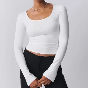 Vit långärmad topp - Snygg vit långärmad topp med en tight passform och rund halsringning. Perfekt för en stilren look. Aldrig använd💕