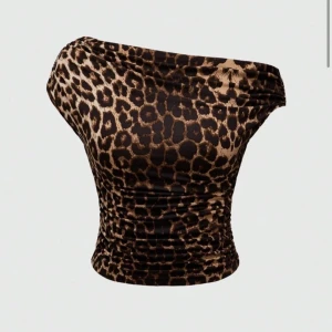 Leopardmönstrad offshoulder topp - Trendig offshoulder topp med leopardmönster. Perfekt för en djärv stil. Toppens design ger en smickrande passform och är ett måste för garderoben.