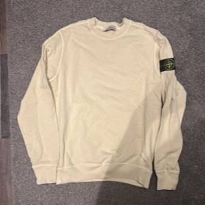 Beige tröja från Stone Island - Säljer en stilren beige tröja från Stone Island. Har aldrig kommit till användning då jag fick den som en gåva. Den är lite stor på mig och storleken är M. om ni är sugna är det bara höra av er.