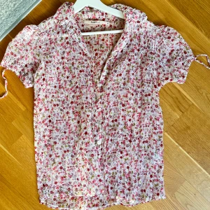 Rosmunde blus - Jättefin somrig rosmundeblus med mönster! Mesh material, passar 38 men skulle nog säga större också! Beroende på passform🩷
