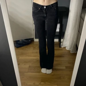 Svarta jeans från gina tricot  - Snygga svarta jeans från gina tricot med en tight passform. De har en klassisk design med fyra fickor och knappgylf. Perfekta för en stilren look.