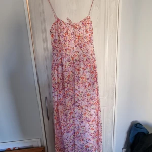 Blommig sommarklänning HM - Knappt använd sommarklänning från HM. Midilång. Resår i midjan och tunna justerbara axelband. Stretchig så passar både M och L utan problem
