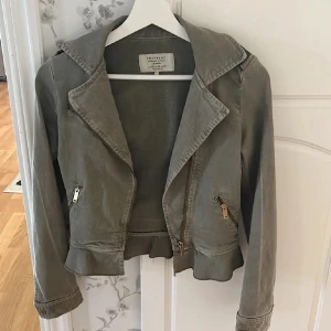 Grön jeansjacka - Säljer den här super snygga jeansjackan från Zara då den inte passar. Den har en fin olivegrön färg med snygga volanger längst ner. Perfekt nu till våren! 