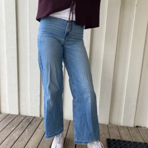 Blå jeans från Lindex - Säljer ett par klassiska blå jeans från Lindex. De har en rak passform och är perfekta för en avslappnad stil. Jeansen har en dragkedja och knapp framtill samt fickor både fram och bak.passar jättefint med nästan vilken tröja som helst 