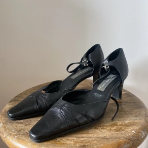 Svarta pumps med klack - Svarta pumps med spetsig tå och klack. Skorna är i fint skick! 