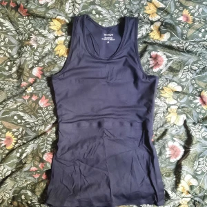 Svart tank top binder från WIVOV - Säljer en svart binder tank top från WIVOV. Binder bra. Perfekt när det är varmt, då den kan användas som linne. Tight passform. Storlek M, men motsvarar XS då deras storlekar är lite annorlunda. Bra men använt skick. En av mina favoriter;)