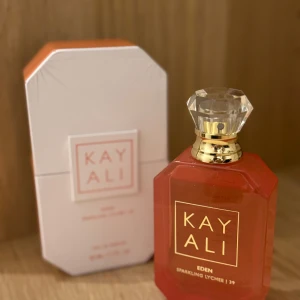 Kayali Eden Sparkling Lychee 39 Parfym - Elegant parfym från Kayali med doften Eden Sparkling Lychee 39. Flaskan är i en vacker röd nyans med en kristalliknande kork. Den är endast testad en gång. 50ml