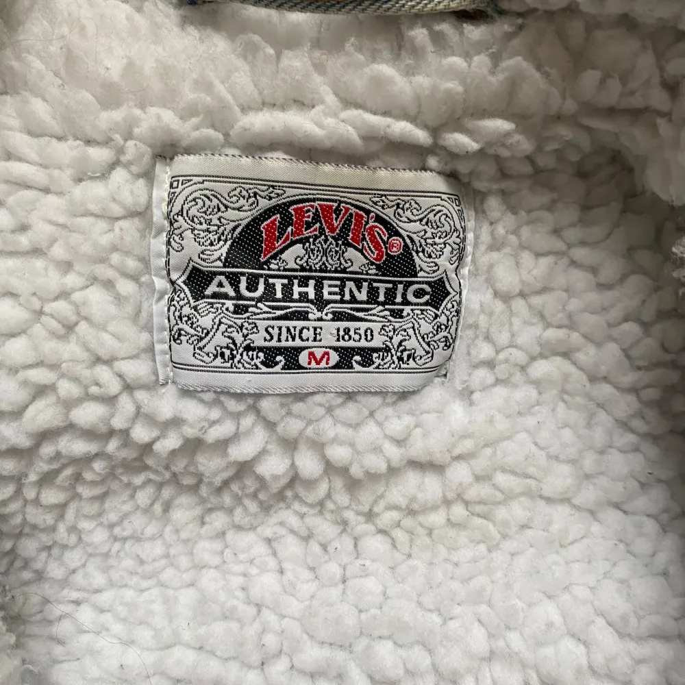 Säljer en vintage ljusblå jeansjacka från Levi's med vitt teddytyg inuti. Jackan har en fläck på ena armen som syns på bilden. Ganska står passform, går mot L. Takit.