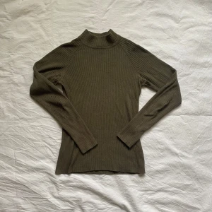 Olivgrön ribbad tröja från Cubus - Säljer en stilren olivgrön ribbad tröja från Cubus. Tröjan har tajt och bekväm passform. 