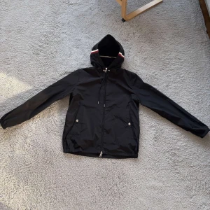 Svart vindjacka från Moncler - Säljer min Moncler windbreaker då jag inte längre använder den. Jackan köptes för 4 månader sedan via Plick för 5 500 kr. Den är i mycket fint skick och knappt använd – ser i princip ut som ny.  Vid en snabb och smidig affär kan jag tänka mig att ta ner priset något.  Hör gärna av dig vid frågor eller för
