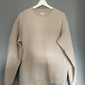 Beige sweatshirt från Jack & Jones - Säljer en stilren beige sweatshirt från Jack & Jones. Tröjan har en klassisk rund halsringning och långa ärmar. Perfekt för en avslappnad look. Passar bra till jeans eller chinos.