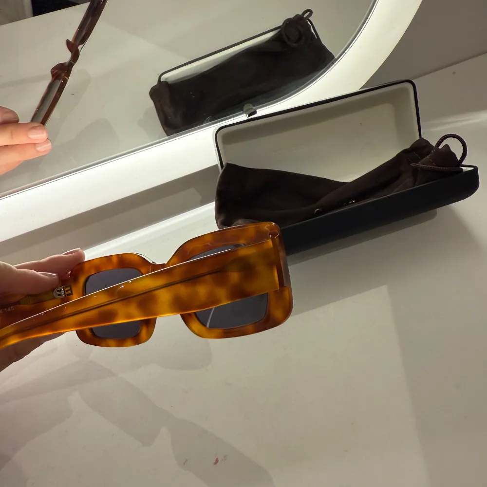 Snygga solglasögon från Corlin med en fyrkantig form och brun sköldpaddsmönstrad båge. De har mörka linser och kommer i ett elegant fodral. Perfekta för en stilren look. Knappt använda! Orange/brun färg beroende på ljus!. Asusteet.