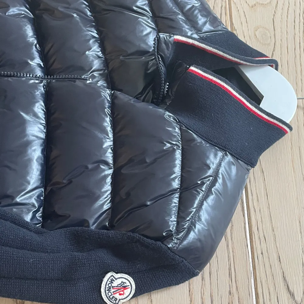 Snygg svart dunväst från Moncler med quiltad design och dragkedja framtill. Västen har ribbade detaljer och en broderad logga på ärmen. Perfekt för kyligare dagar. Fick i present så är därför osäker på äkthet. Därav priset (:. Takit.