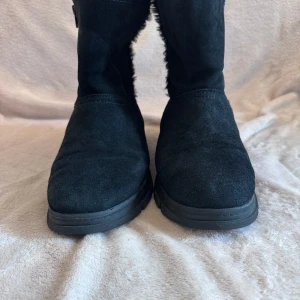 Svarta boots med dragkedja - Snygga svarta boots i mocka med dragkedja på sidan. De har en mjuk insida med pälsdetaljer som håller fötterna varma under kalla dagar. Perfekta för vintern och hösten.
