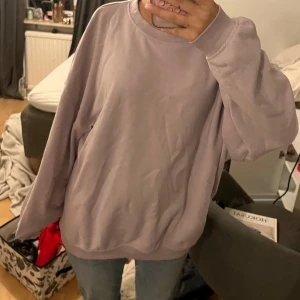 Ljuslila sweatshirt - *obs den har fläck se på andra bilden* Säljer en mysig ljuslila sweatshirt med rund hals och långa ärmar. Perfekt för en avslappnad stil. Passar bra till jeans eller leggings. 
