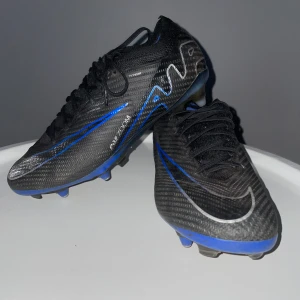 Nike Air Zoom Mercurial Vapor 15 Elite - Skorna är i hyfsat bra skick gummit under skon har gått sönder lite men de märks inte på plan.        Nypris är 3249kr Storlek 40 Skoegenskap:Snabbhet Anticlog dubbar funkar bra för herr och dam skomaterial stickat påse och box får man på köpet