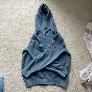 Blå hoodie från Ralph Lauren - Säljer en snygg blå hoodie från Ralph Lauren med det klassiska logotypbroderiet på bröstet. Tröjan har en bekväm passform med långa ärmar och en praktisk huva med dragsko. Perfekt för en avslappnad stil.