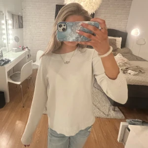 Vit stickad tröja - Säljer en stilren vit stickad tröja med långa ärmar. Perfekt för kyligare dagar och enkel att matcha med olika outfits. Lite nopprig och syns att den är använd, en ton av en fläck bild 2 och en mini fläck på ärmen💕