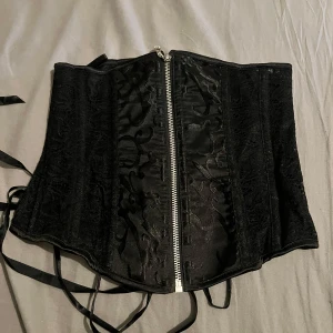 Korset  - Oanvänd.   Har ryggrem för att justera midjan