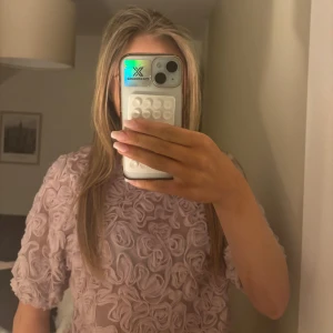 Ljusrosa blus med rosdetaljer - Säljer en ljusrosa blus med unika rosdetaljer över hela tyget. Blusen har korta ärmar och en lös passform som ger en romantisk look. Perfekt för att piffa upp garderoben med något speciellt! 🌸