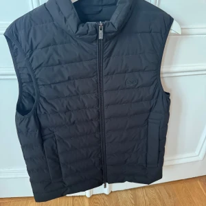 Armani väst  - Stilren Emporio Armani väst i storlek 48. Endast använd 2 gånger. Tveka inte på att höra av dig vid yttligare frågor och funderingar!