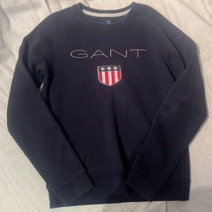 Mörkblå tröja från GANT - Säljer en snygg mörkblå tröja från GANT, favorit hoodien för några år sen då den blivit för liten. Tröjan har rätt så långa ärmar och rund halsringning. Perfekt för en stilren look. Den är liten så passar lite mindre personer. Storlek XS| minns inte nypriset då jag köpte den 2016 i gant butiken men skulle gissa på 1200kr. Sitter som en smeck!