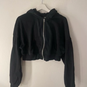Svart croppad hoodie - Säljer en svart croppad hoodie med dragkedja. Ska flytta snart så vill gärna bli av med allt så fort som möjligt (pris kan diskuteras)💕
