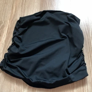 Svart tubb top - Snygg svart tubtop med en enkel och stilren design. Perfekt för en dag på stranden eller vid poolen. Den har en klassisk passform som är både bekväm och smickrande.