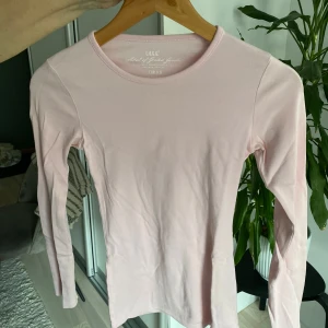 Ljusrosa långärmad topp från L.O.G.G. - Säljer en ljusrosa långärmad topp från L.O.G.G. i en mjuk och bekväm bomullsmix. Perfekt för lager-på-lager eller som den är. Enkel och stilren design som passar till det mesta. 🌸
