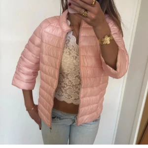 Rosa pufferjacka - Säljer en snygg rosa jacka med dragkedja framtill. Jackan har trekvartsärmar och en quiltad design som ger en trendig look. Perfekt för vår och sommar! Storleken är M men skulle säga att den är lite mindre, som man ser på bilderna!