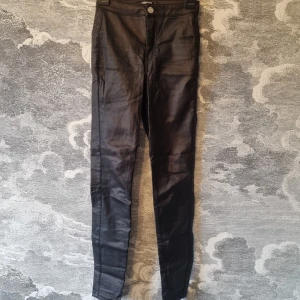 Svarta byxor från Missguided - Snygga svarta byxor från Missguided i petite-modell. De har en hög midja och en tight passform som framhäver benen. Är i mycket bra skick. Jag hittar ingenting att anmärka på.