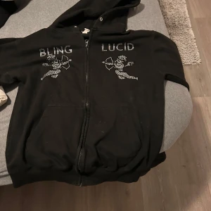 Svart hoodie med blingdetaljer - Säljer en svart hoodie med dragkedja från lucid. Lite använd men inte mycket. Men pris kan också diskuteras 