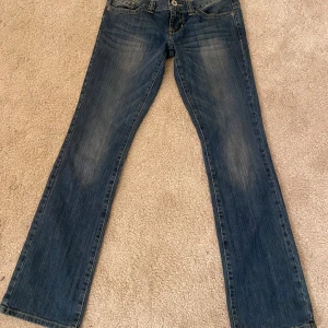 Blå lågmidjade bootcut jeans från Guess - Säljer dessa jätte snygga jeans från guess!pris kan diskuteras