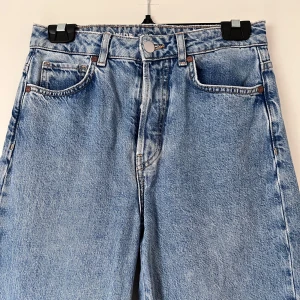 Blå jeans - Snygga blå jeans med hög midja och rak passform. Klassisk femficksdesign med knapp och dragkedja framtill. Perfekta för en avslappnad stil. Använda 1 gång! Önskar du veta exakta mått? Tveka inte att höra av dig!