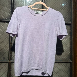 Ljuslila stickad t-shirt  - En ljuslila stickad t-shirt från Davinson Cremieux. Den har en rund halsringning och korta ärmar. Perfekt för en avslappnad stil. Passar bra till jeans eller kjol. 💜 