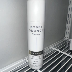 Bobby Oduncu Hair Mousse - Använd ca 3 gånger. Volymgivande hårmousse från Bobby Oduncu Sweden. Produkten är 100% vegansk och tillverkad i Sverige. Kommer i en vit flaska med guldiga detaljer och text. Perfekt för att skapa fyllighet och stadga i håret.      