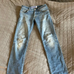 Blå jeansbyxor från Jack & Jones - Säljer ett par klassiska blå jeans från Jacob Cohen storlek 31. Byxorna har normal passform, fem fickor och snygga slitningar framtill för en trendig look. Perfekta till vardags med en t-shirt eller hoodie.