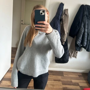 Ljusgrå stickad tröja - Mysig ljusgrå stickad tröja med lång ärm och ribbade muddar. 