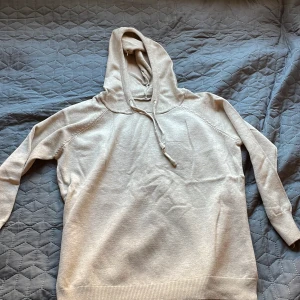 Merinoull hoodie  - Säljer en stilren beige merinoull hoodie. Perfekt för en avslappnad look. 