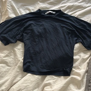 Marinblå t-shirt från lager 157 - Marinblå t-shirt från lager 157 i storlek S. T-shirten har en klassisk rund halsringning och korta ärmar. Passformen är normal och materialet känns mjukt och bekvämt, perfekt för en avslappnad stil.