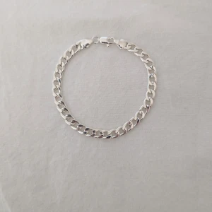 Kedjearmband i silverfärg - Stilrent armband med breda, platta länkar i silverfärg. Klassisk kedjedesign med karbinlås, passar perfekt som accessoar till olika outfits. Enkel och tidlös look.