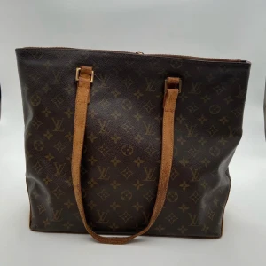 Monogram axelväska från Louis Vuitton - Intressekoll på min Louis Vuitton Cabas Mezzo. Mycket rymlig, perfekt för skolan  Skick: C/D, väldigt fint vintage skick utom åtgärd som krävs för att få dragkedjan fullt fungerande. Självklart äkta.   Serienummer: AR1011  Sku: V027  Mått: B38cm x H33cm x D16cm