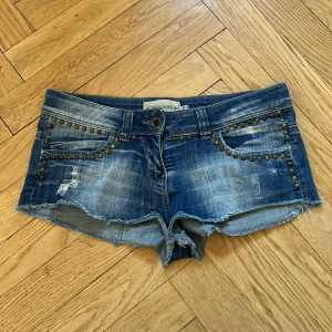 Blå jeansshorts med nitar - Korta lågmidjade jeansshorts från Bershka. Köpta på Vinted men passar tyvärr inte mig. En av nitarna har ramlat av och några är lösa. De är vädligta korta, skulle kunna vara jeans som har klippts till shorts.🩷🩷                                            Midjemått: 39cm (men lite stretchigt material) Längd: 20cm                                                                  Lår: 21cm
