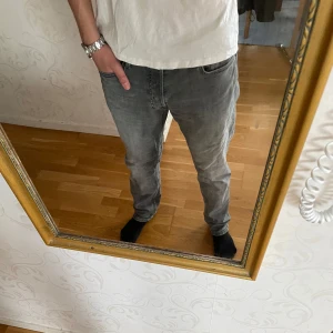 Gråa Jack & Jones jeans  - Säljer ett par gråa Jack & Jones i modellen tapered Mike, har normal passform som på bilden. Knappt använda jeans så de är fortfarande i topp skick, nypris runt 800 kr, mitt pris: 299 kr 