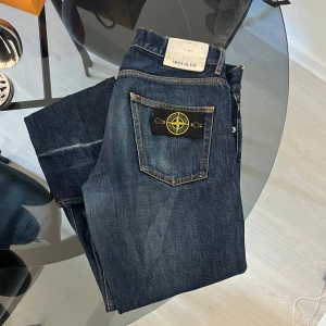 Mörkblå jeans från Stone Island - Säljer ett par mörkblå jeans från Stone Island. Slitna nertill då de användas uppvikta. Storlek 30/34. 