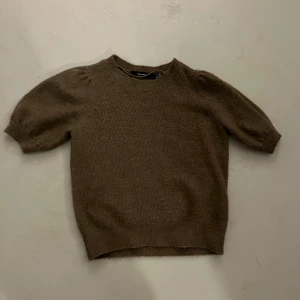 Brun stickad tröja från Vero Moda - Mysig brun stickad tröja från Vero Moda med kortare puffärmar och rund halsringning. Använd en del och är därmed nopprig!! Skriv för fler bilder eller detaljer😇💓
